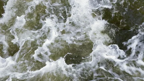 Dark brown water lapping below in slow motion with a lot of foam and spray. Stock Footage 139301281