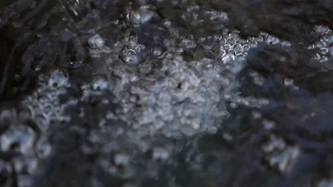 Dark bubbling liquid surface close up with sharp foam details rising air pockets Stock Footage 306007425