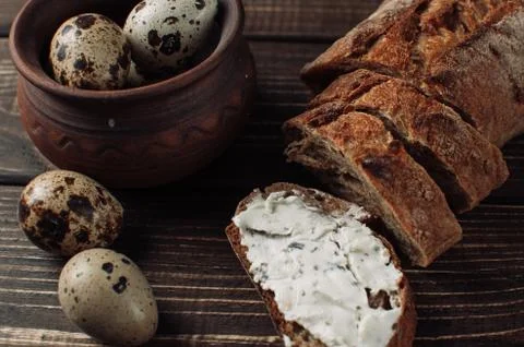 Dark buckwheat bread is spread with cottage cheese with herbs in a cut Stock Photos
