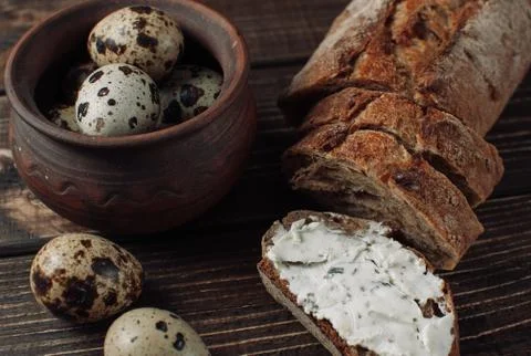 Dark buckwheat bread is spread with cottage cheese with herbs in a cut Stock Photos