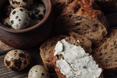 Dark buckwheat bread is spread with cottage cheese with herbs in a cut Stock Photos