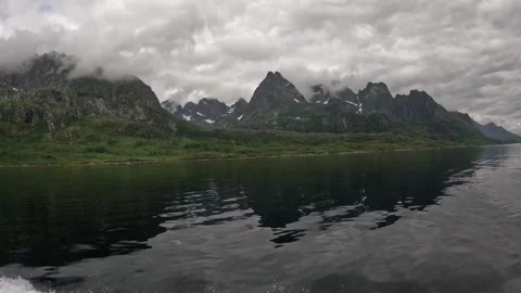 Dark calm fjord reflecting sharp cloudy mountain peaks in Lofoten Vídeos de archivo 344753101
