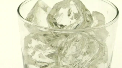Dark, carbonated liquid is poured over ice into a glass. Stock Footage