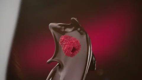 Dark chocolate and fresh raspberry falling in slow motion Stock Footage 253702097
