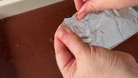 Dark Chocolate Bar Unwrapped from Silver Foil by Female Hands Beside Fresh Stock Footage 345179156