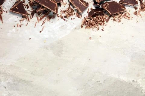 Dark chocolate bars on stone table and broken pieces of cocoa Stock Photos