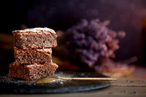 Dark chocolate brownies stack, lavender flowers Stock Photos