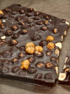 Dark chocolate with caramelized hazelnuts cut into large pieces and display.. Stock Photos