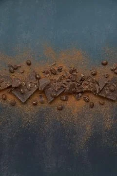 Dark chocolate, chips and cocoa powder with coffee beans on dark background. Stock Photos