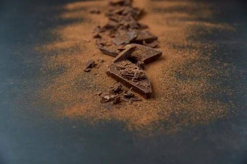 Dark chocolate, chips and cocoa powder with coffee beans on dark background. Stock Photos