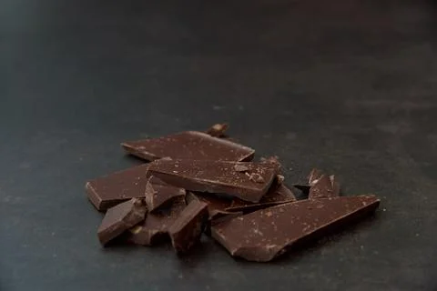 Dark chocolate, chips on a dark background. Confectionery and food concept. Stock Photos