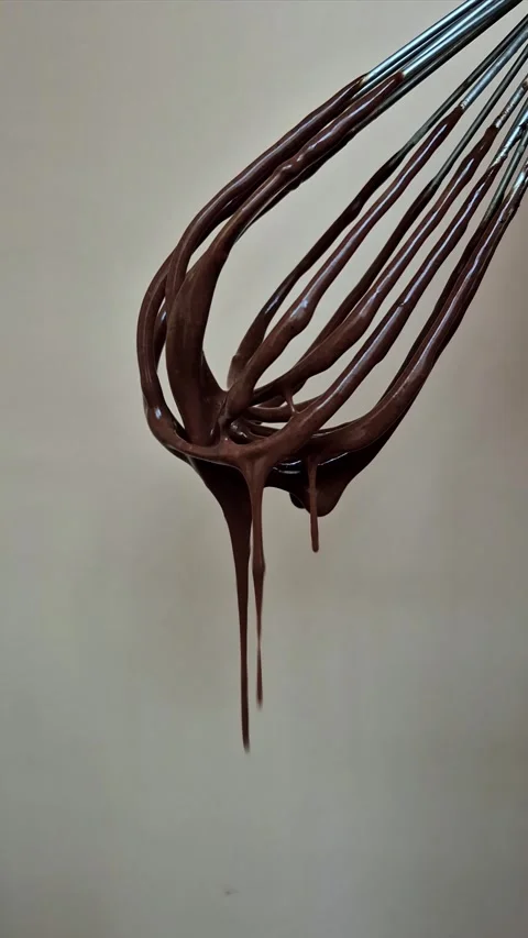 Dark chocolate drips from the whisk Stock Footage 306474546