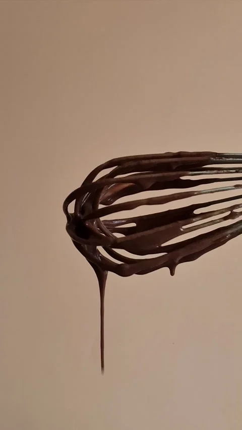 Dark chocolate drips from the whisk Stock Footage 306474547