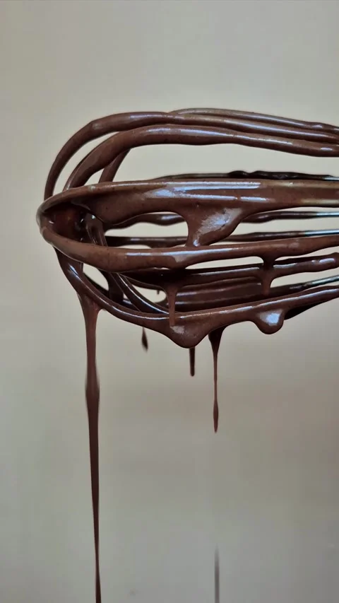 Dark chocolate drips from the whisk Stock Footage 306474557