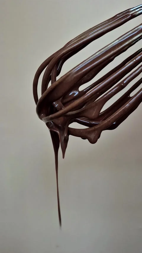 Dark chocolate drips from the whisk Stock Footage 306474558