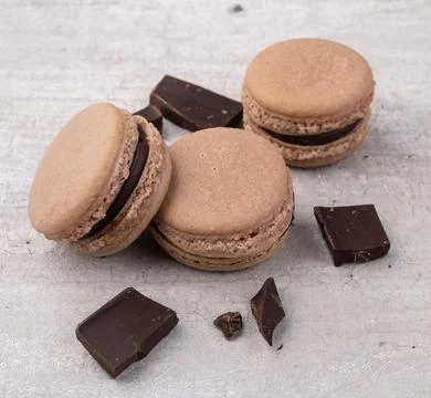 Dark chocolate macarons over rustic background Fotos Stock