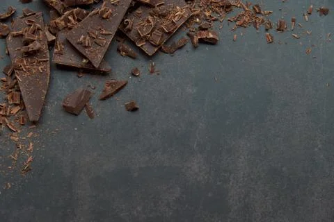 Dark chocolate stack and chips on a dark background. Confectionery concept. Stock Photos