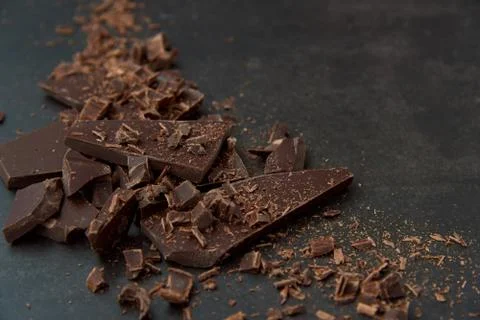 Dark chocolate stack and chips on a dark background. Confectionery concept. Stock Photos