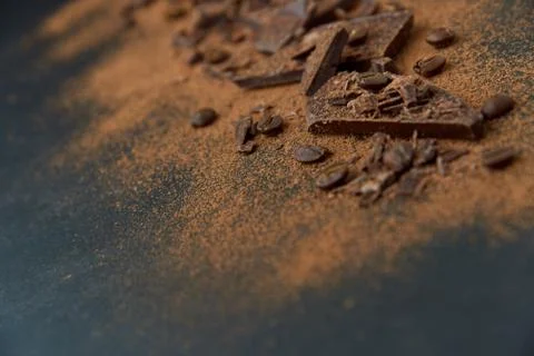 Dark chocolate stack and cocoa powder with coffee beans on a dark background. Stock Photos