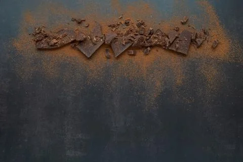 Dark chocolate stack and cocoa powder with coffee beans on a dark background. Stock Photos