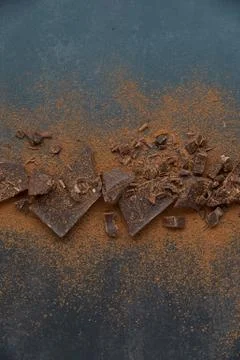 Dark chocolate stack and cocoa powder with coffee beans on a dark background. Stock Photos