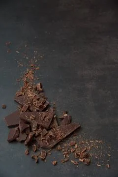 Dark chocolate stack, chips and cocoa powder on a dark background. Stock Photos