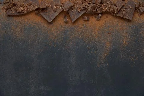 Dark chocolate stack, chips and cocoa powder on a dark background. Stock Photos