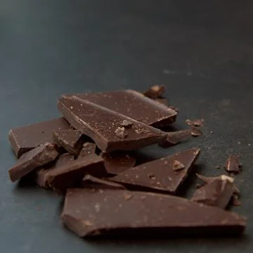 Dark chocolate stack on a dark background. Confectionery and food concept. Stock Photos