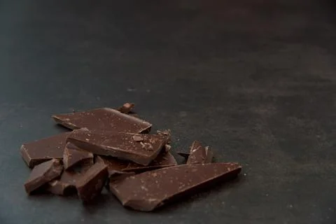 Dark chocolate stack on a dark background. Confectionery and food concept. Stock Photos