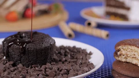 Dark chocolate syrup poured on a slice of mouthwatering chocolate cake Stock Footage 153199704