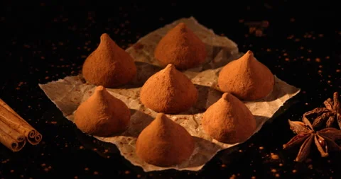 Dark chocolate truffles rotating on a black surface. Filmed with RED camera. Stock Footage 155343613