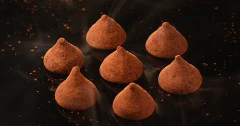 Dark chocolate truffles rotating on a black surface. Filmed with RED camera. Stock Footage 155392934
