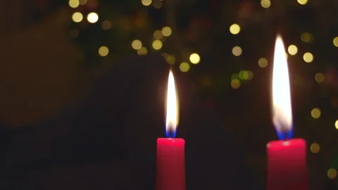 Dark Christmas background with thin red burning candles and glowing garland ligh Stock Footage 325973938