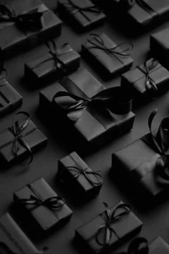 Dark Christmas theme. Square boxed gifts wrapped in black paper and ribbon 写真素材