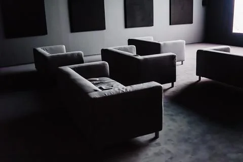 Dark Cinema with Sofas Illuminated by the Screen Infront of them Stock Photos