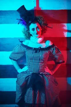 The dark circus concept. Circus performer in a clown costume performs a knife Stock Photos