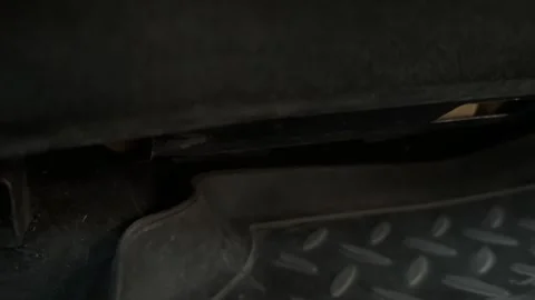 Dark close-up of a rubber floor mat and lower seat area inside a car, vehicle Stock Footage 337113419