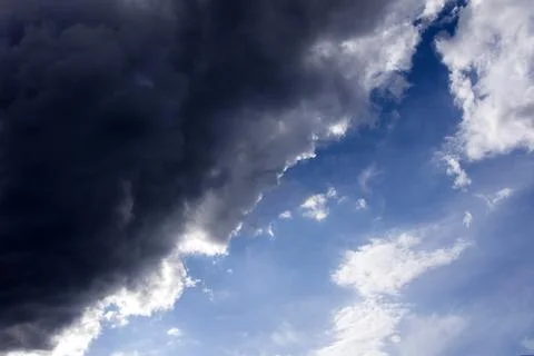 A dark cloud covers the blue sky. before the storm and thunder Stockfoto's