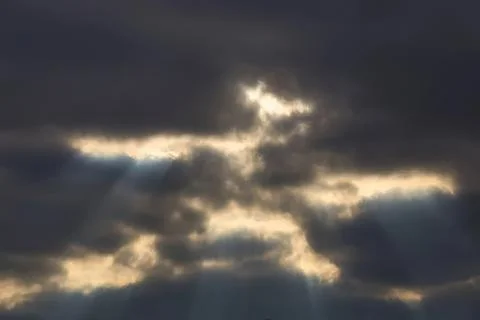 Dark cloud sky with sunlight rays breaking through clouds 스톡 사진