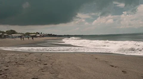Dark clouds above bali beach, some horse riders in the distance Stock Footage 63659762