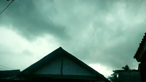 Dark clouds and strong winds above the houses in the countryside Video stock 303887052
