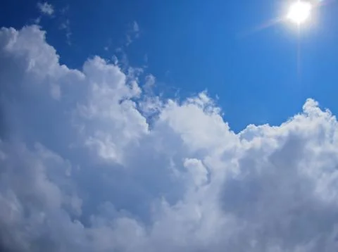 Dark clouds, blue sky and bright sun Stock Photos