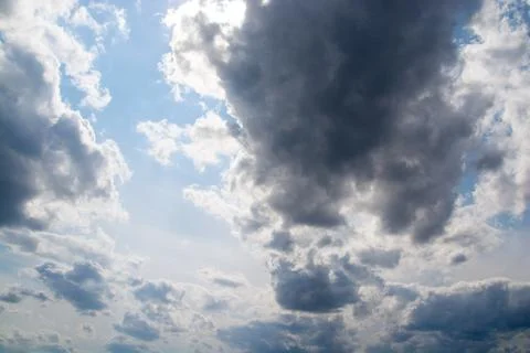 Dark clouds in a blue sky close-up. Stock Photos