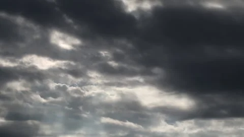 Dark clouds with bright sun beams - sky background with sunrays - Time Lapse Stock Footage 153842454