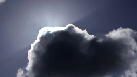 Dark clouds with bright sun beams - sky background, sunrays - real time Stock Footage 153953783