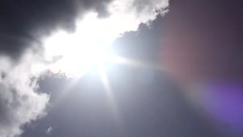 Dark clouds with bright sun beams - sky background, sunrays - real time Stock Footage 153953792