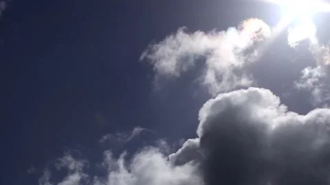 Dark clouds with bright sun beams - sky background, sunrays - real time Stock Footage 153964912