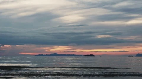 Dark clouds with colorful horizon during sunset over tropical sea Stock Footage 331835936