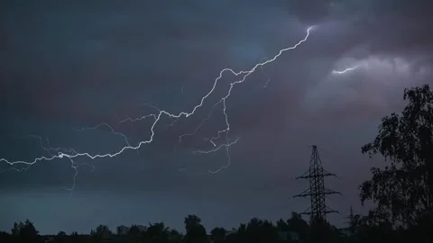 Dark clouds cover the sky as lightning strikes through the atmosphere, creating Stock Footage 339024172