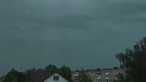 Dark clouds covered the residential area with buildings and trees, lightning Stock Footage 344440880